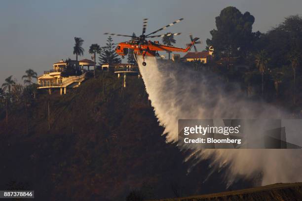 An Erickson Inc. Air Crane firefighting helicopter makes a water drop during the Skirball Fire in the Bel Air neighborhood of Los Angeles,...