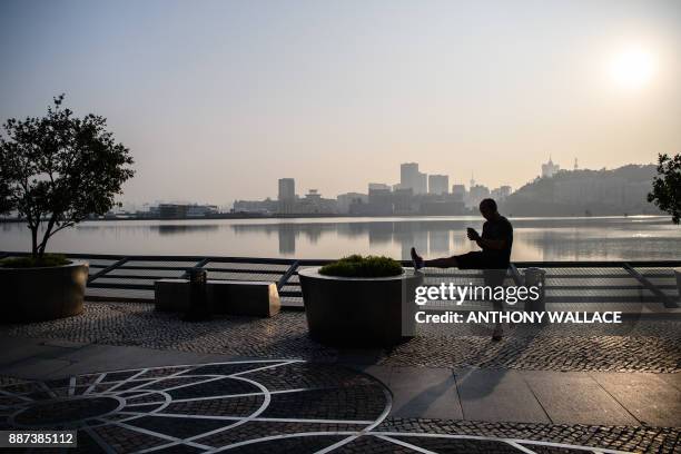 This picture taken on December 6, 2017 shows a man stretching his leg in Macau. - Gambling hub Macau and several countries protested on December 6...