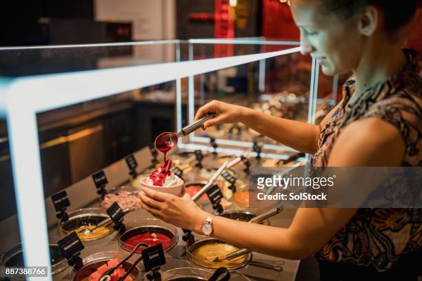 female using self service frozen yoghurt bar - frozen yoghurt stock pictures, royalty-free photos & images
