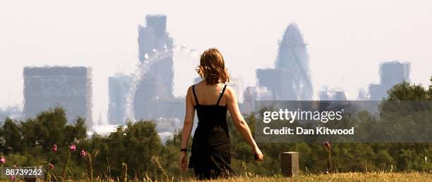 Woman walks past a view of the City of London in Richmond Park on June 29, 2009 in London, England. The Met Office has announced a weather warning...