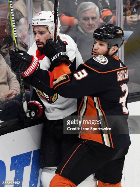 Anaheim Ducks defenseman Kevin Bieksa knocks Ottawa Senators center Nate Thompson into the boards in the second period of a game played on December...