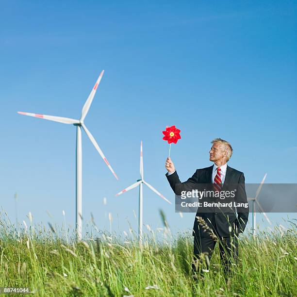 businessman holding windmill - paper windmill stock-fotos und bilder