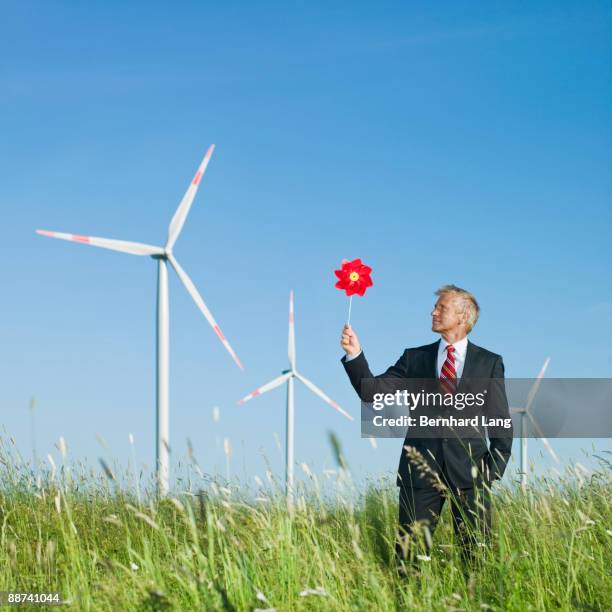 businessman holding windmill - the whirligig stockfoto's en -beelden