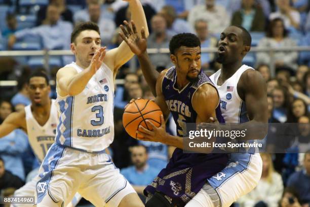 Western Carolina guard Devin Peterson is defended by North Carolina guard Andrew Platek and guard Theo Pinson during the game between the North...