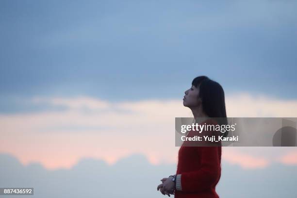 frau und den sonnenuntergang wolken - japanese woman looking up stock-fotos und bilder