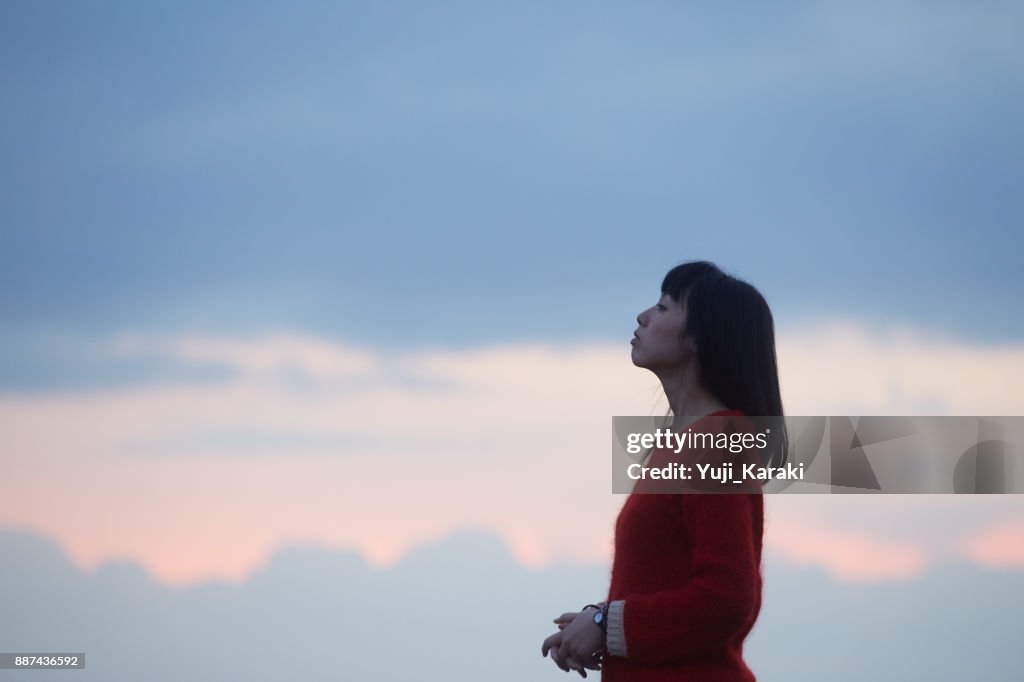 女性と夕焼け雲