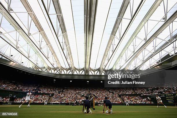 Andy Murray of Great Britain in action under the new Centre Court roof during the men's singles fourth round match against Stanislas Wawrinka of...