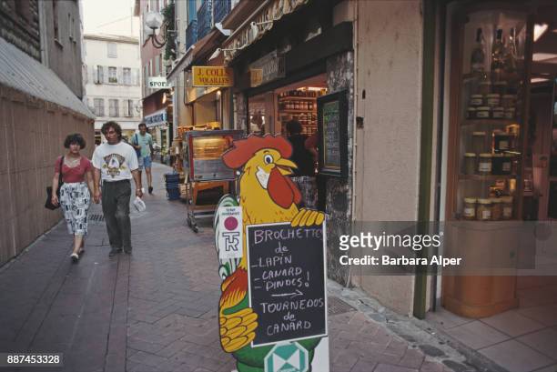 Rooster-shaped sign informs people on the local delicacies of a shop in an alley in Perpignan: rabbit, duck, turkey skewer and duck tournedos,...