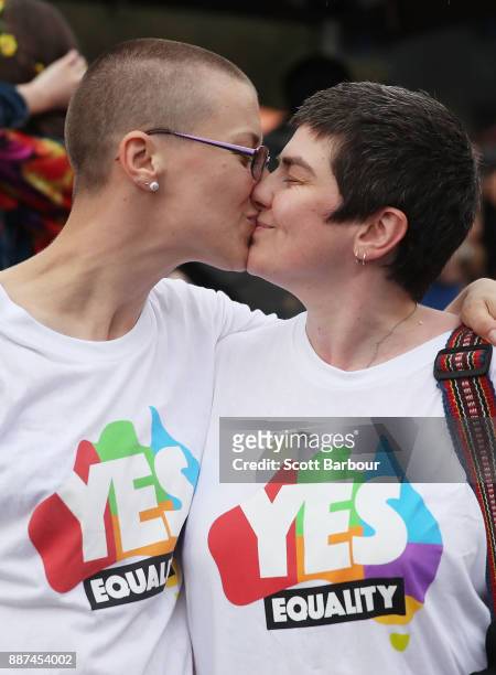 Tracy Clark and her partner Justyna Greinart embrace as they gather with a crowd of people to watch a large television screen at Federation Square as...