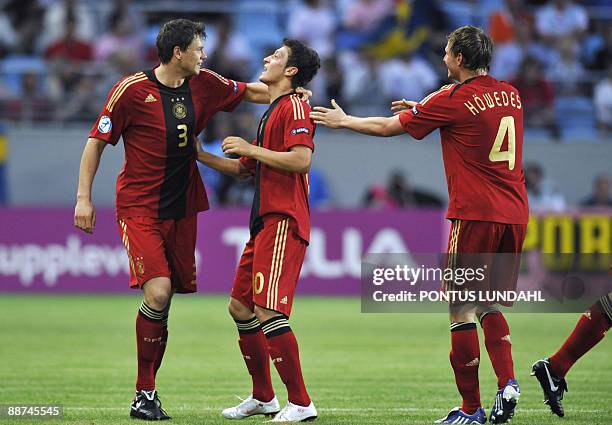 Germany's Mesut Ozil and teammates Sebastian Boenisch and Benedikt Howedes celebrate after Ozil's goal in their Under 21 European Championship final...