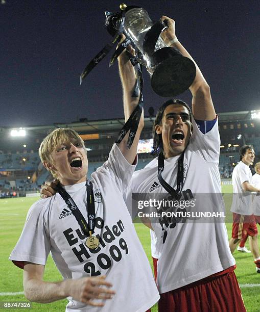 Germany's team captain Sami Khedira and Andreas Beck thank the fans as they hold up their trophy after their victory over England in the Under 21...