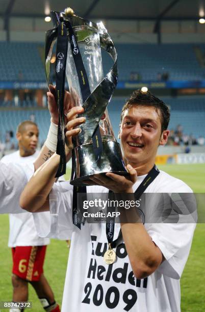 Germany's Mesut Ozil holds up the trophy their victory over England in the Under 21 European Championship final at the Malmo New Stadium on June 29,...