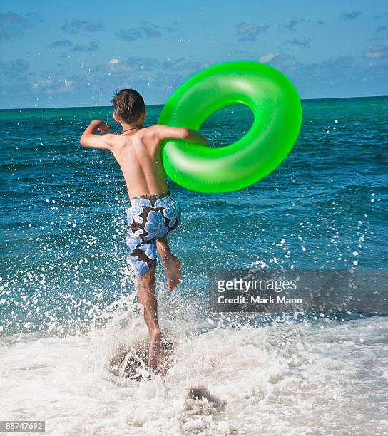 young boy jumping in the waves. - captiva island stock-fotos und bilder