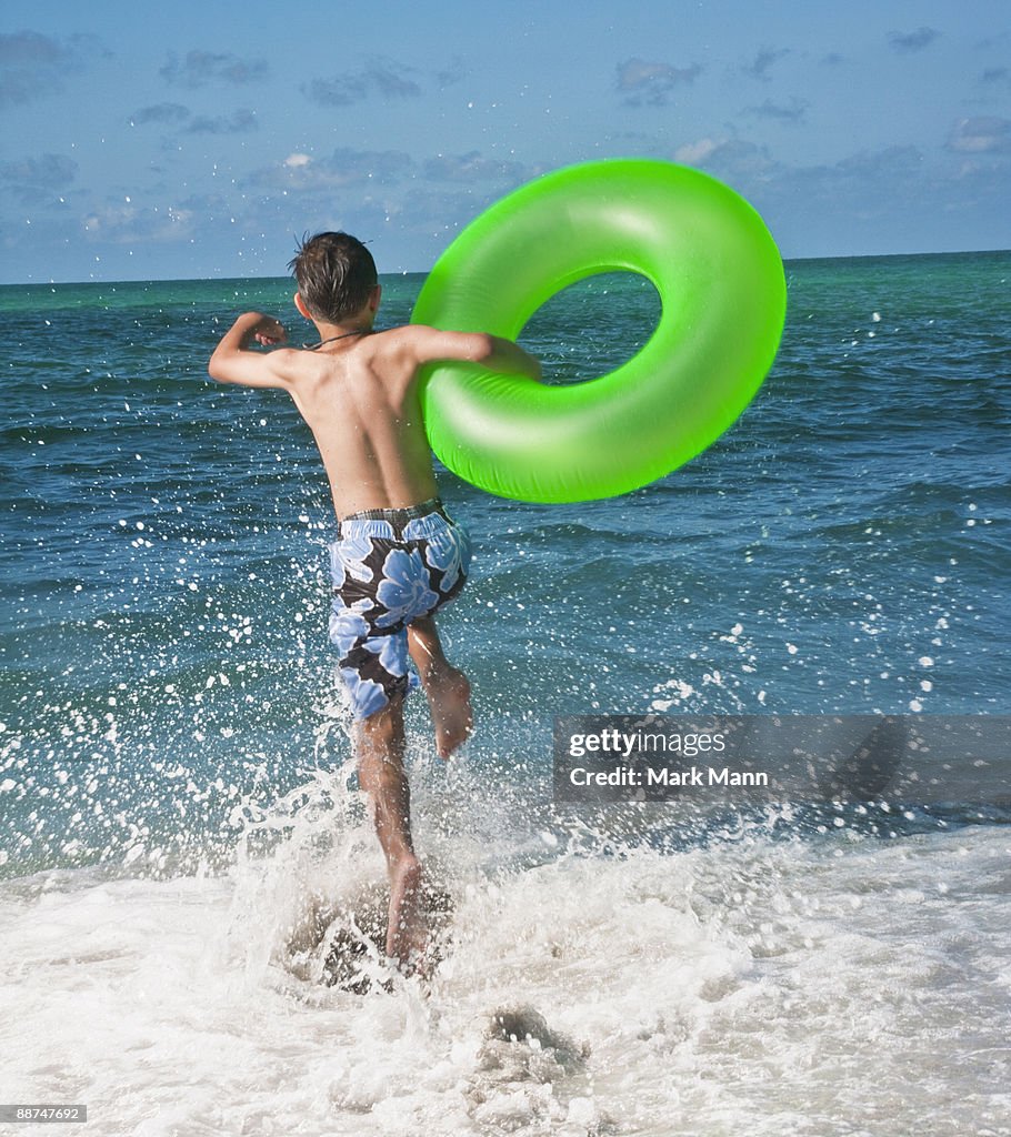 Young boy jumping in the waves.