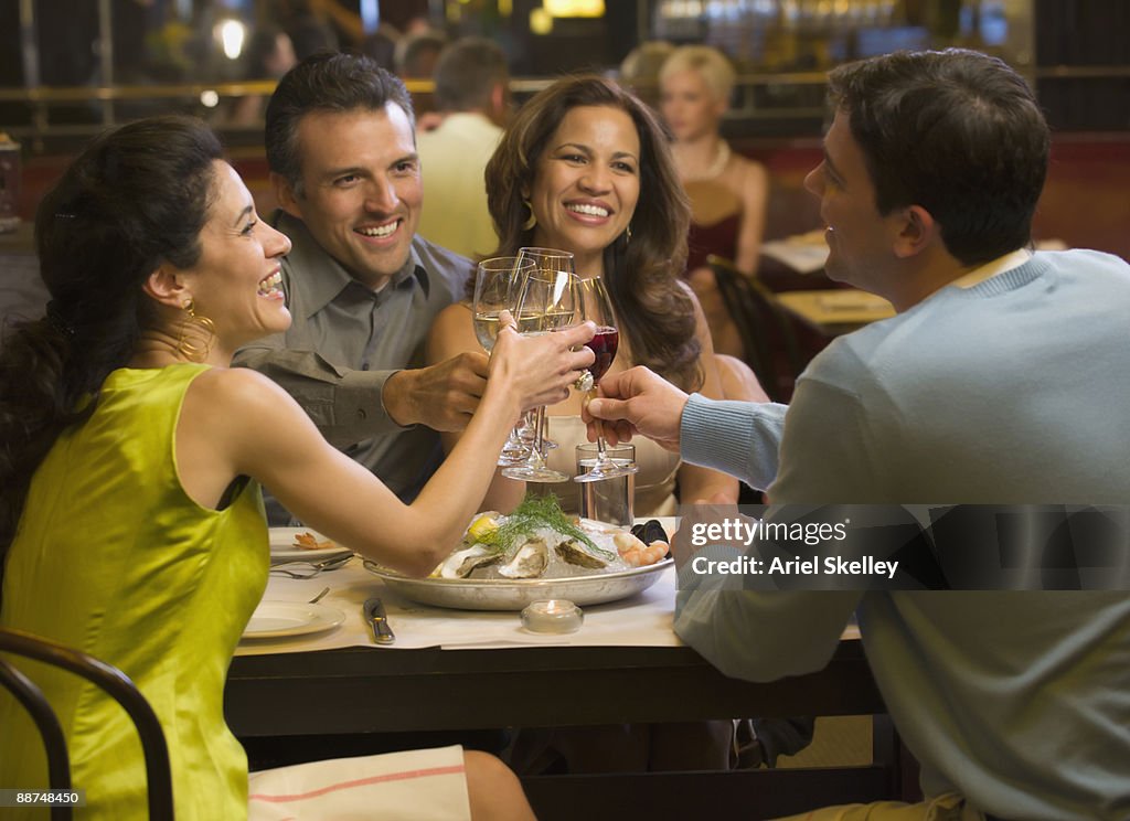 Two couples having dinner in restaurant