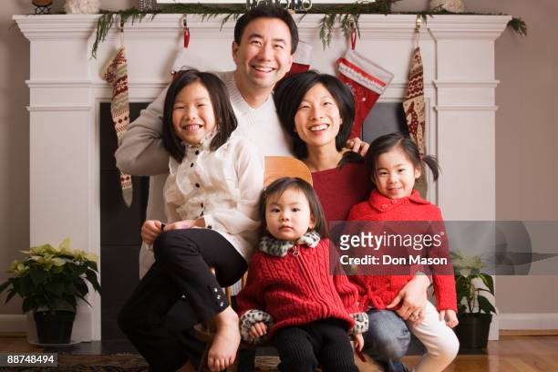 asian family posing for christmas photograph - stockings fotos stock-fotos und bilder