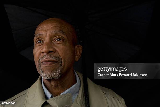 african businessman holding umbrella - ziegenbart stock-fotos und bilder