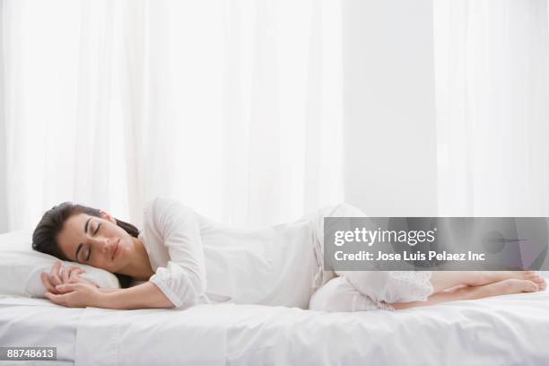 hispanic woman sleeping in bed - acostado fotografías e imágenes de stock