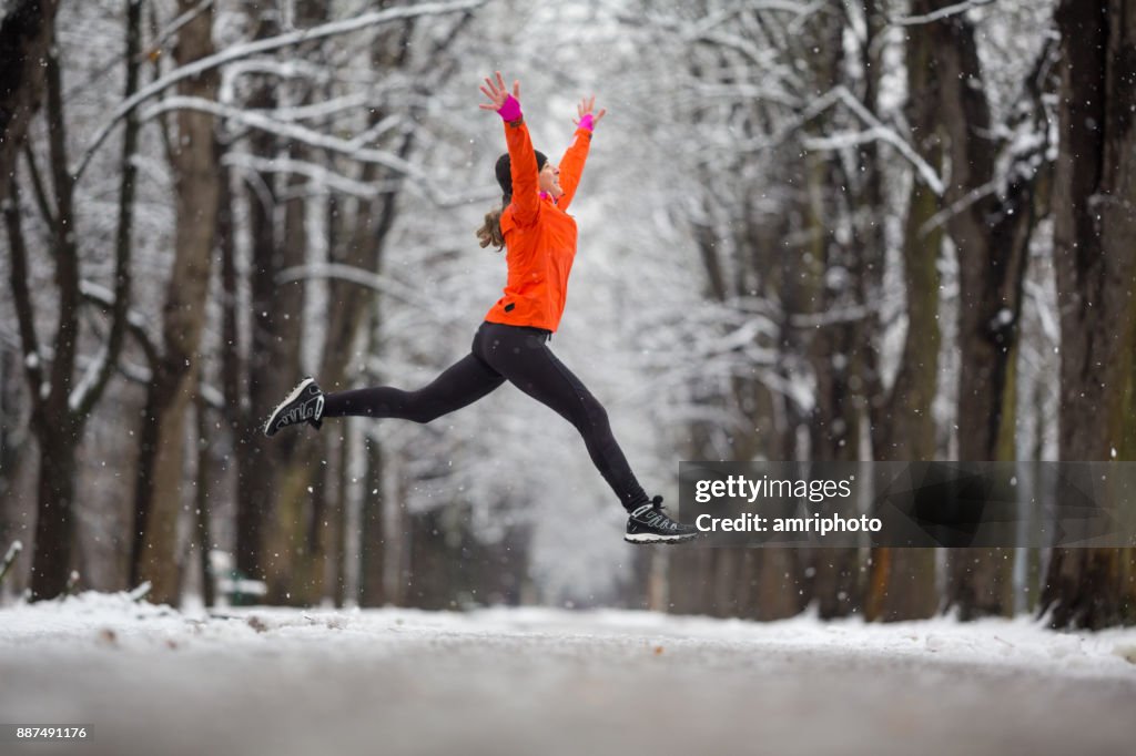 Jump ! -femme de vue côté sautant de joie en hiver