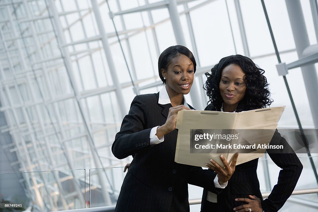 African businesswomen viewing folder
