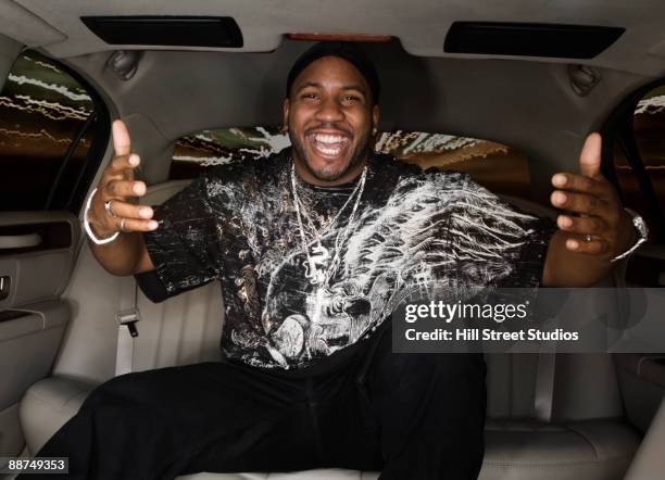 african man gesturing in back seat of car - black bling stock pictures, royalty-free photos & images