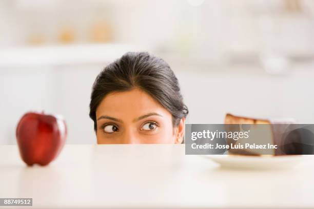 indian woman choosing snack - apple cake stock pictures, royalty-free photos & images