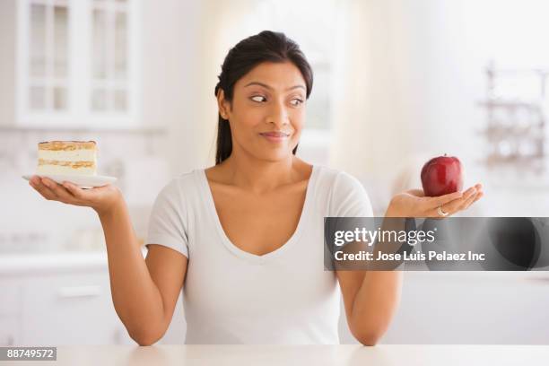 indian woman choosing snack - frau apfel stock-fotos und bilder