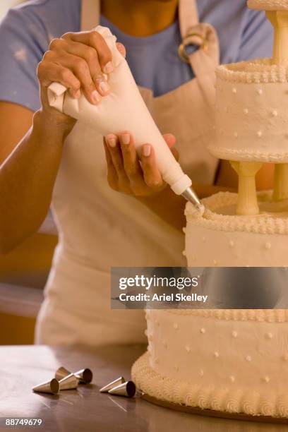 hispanic woman decorating wedding cake - decorating a cake fotografías e imágenes de stock