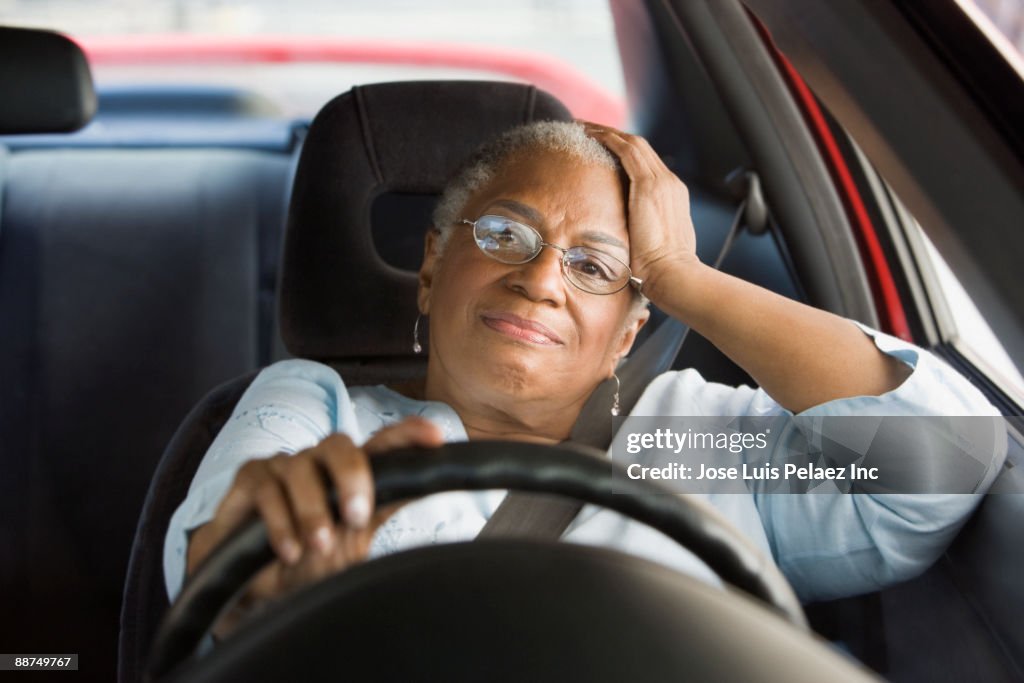 African woman driving car in traffic