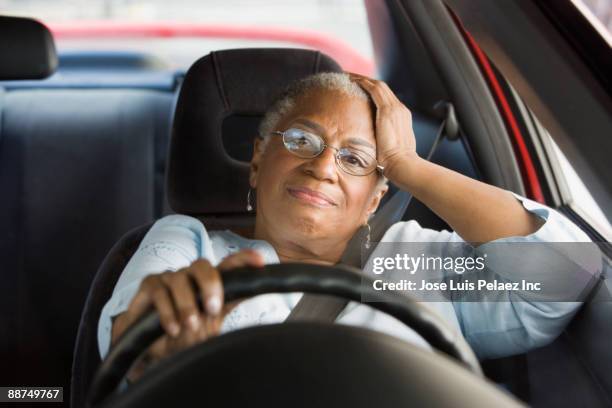 african woman driving car in traffic - sitting in car stock pictures, royalty-free photos & images