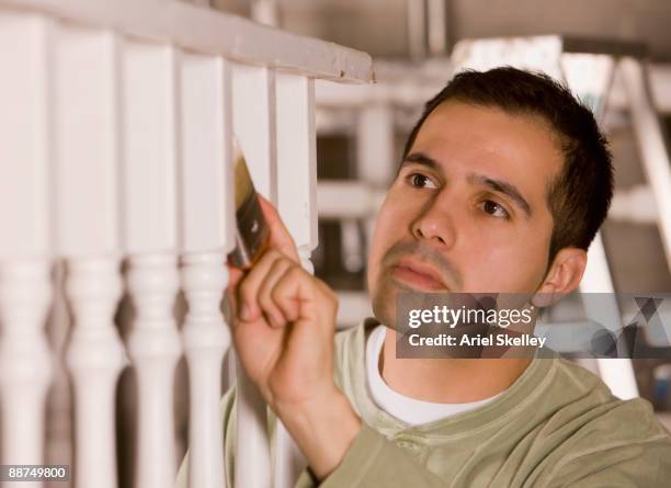 hispanic man painting railing - treppengeländer stock-fotos und bilder