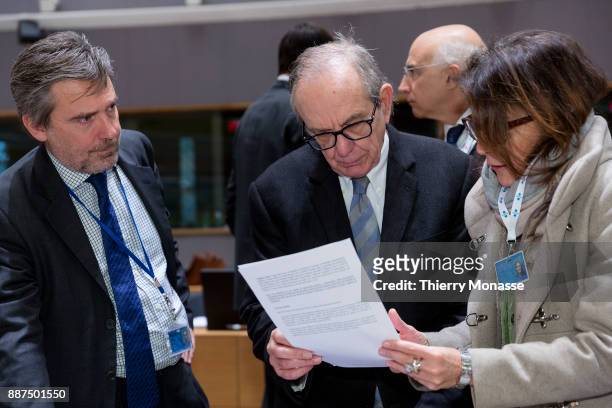 Italian Minister Economy & Finance Pier Carlo Padoan is looking at papers with staff members prior an EcoFin Ministers meeting on December 5, 2017 in...