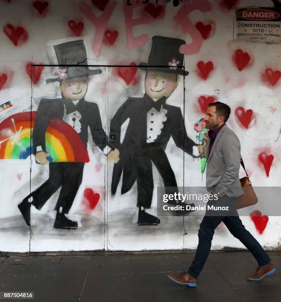 Pedestrian walks past a graffiti celebtating same sex marriage on December 7, 2017 in Sydney, Australia. The historic bill was passed on the final...