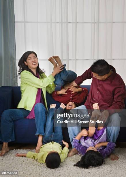 asian family rough housing in living room - holding upside down stock pictures, royalty-free photos & images