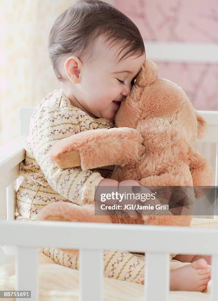 mixed race baby girl snuggling teddy bear - teddybear imagens e fotografias de stock