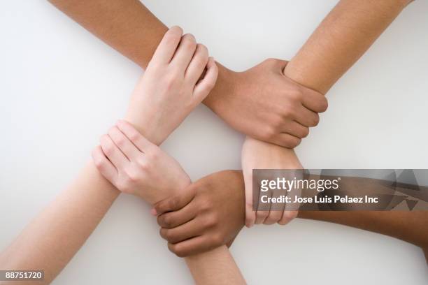 teenage friends gripping each other's wrists - ethnische zugehörigkeit stock-fotos und bilder
