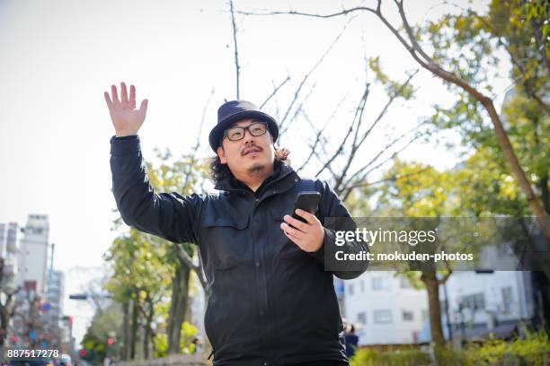 a man touching a  smart phone in a park - management car smartphone stock pictures, royalty-free photos & images