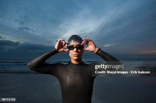 hispanic woman in wetsuit on beach - swimming goggles stock pictures, royalty-free photos & images