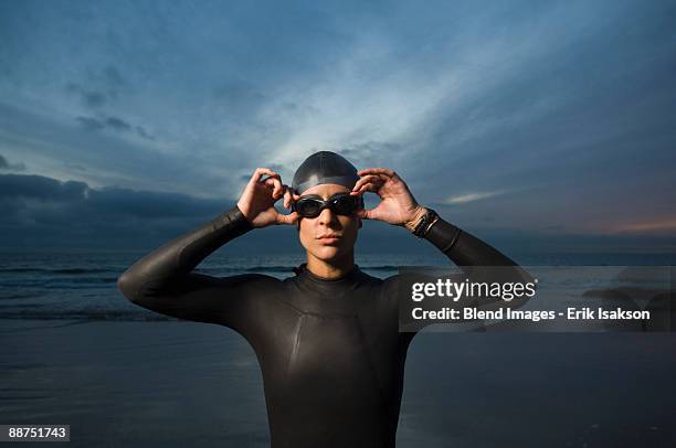 hispanic woman in wetsuit on beach - goggles sportswear stock pictures, royalty-free photos & images