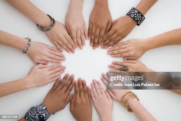 teenage friends with hands placed in a circle - gruppen im kreis stock-fotos und bilder