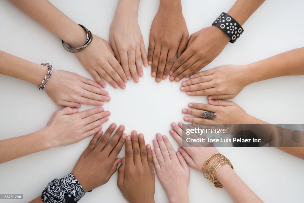 Teenage friends with hands placed in a circle