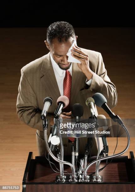 african american man sweating at press conference podium - press conferences fotografías e imágenes de stock