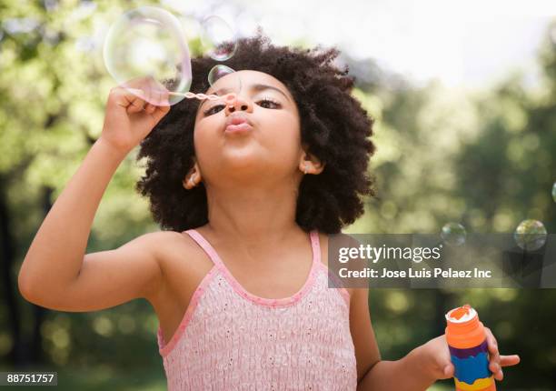 mixed race girl blowing bubbles - child bubble stock pictures, royalty-free photos & images