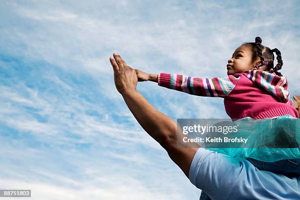 african father carrying daughter on shoulders - llevar al hombro fotografías e imágenes de stock