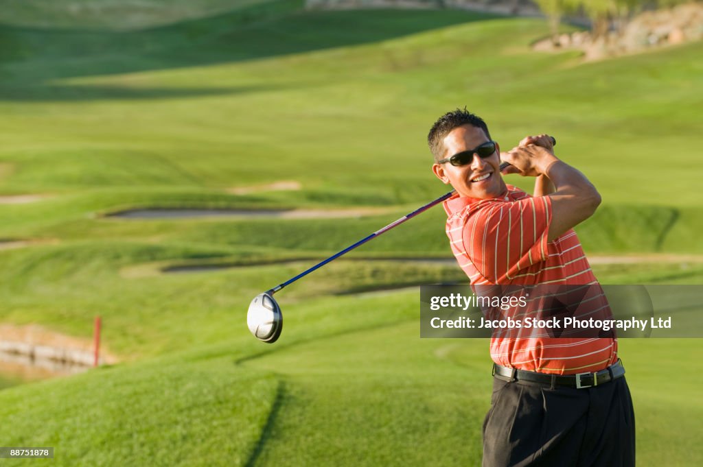 Hispanic man playing golf
