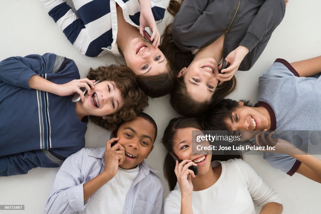Friends Talking Using Phones Teenage Friends Laying On Floor Talking On Cell Phones High-Res Stock ...