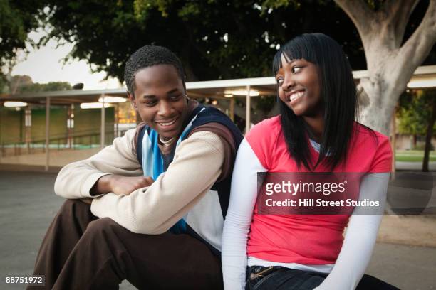 african teenage couple sitting in school yard - casal adolescente imagens e fotografias de stock
