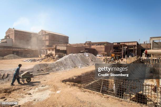 Workers labor in a construction site for new facilities at the Shabbir Tiles & Ceramics Ltd. Production facility in Karachi, Pakistan, on Wednesday,...