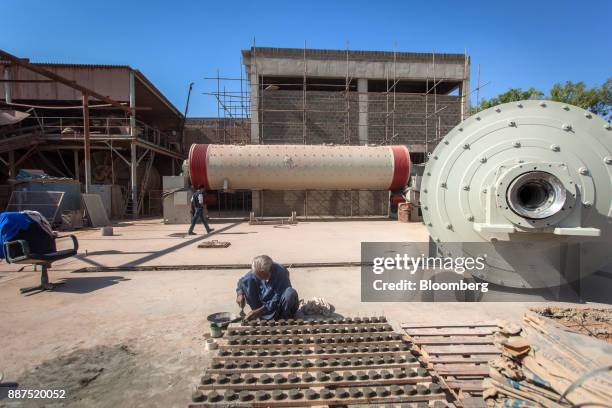 An employee works near two new ball mills in a construction site for new facilities at the Shabbir Tiles & Ceramics Ltd. Production facility in...