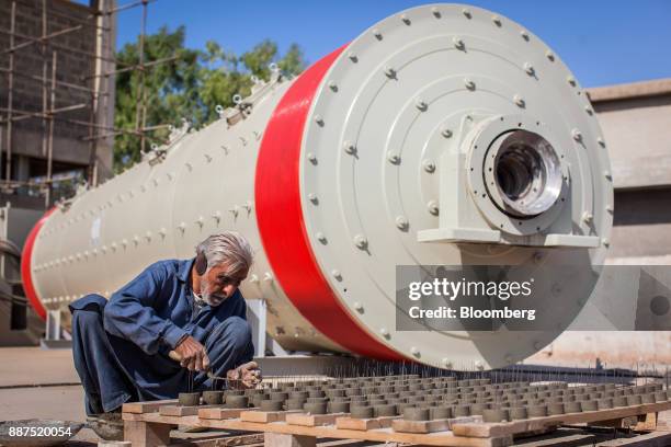 An employee works next to a new ball mill in a construction site for new facilities at the Shabbir Tiles & Ceramics Ltd. Production facility in...